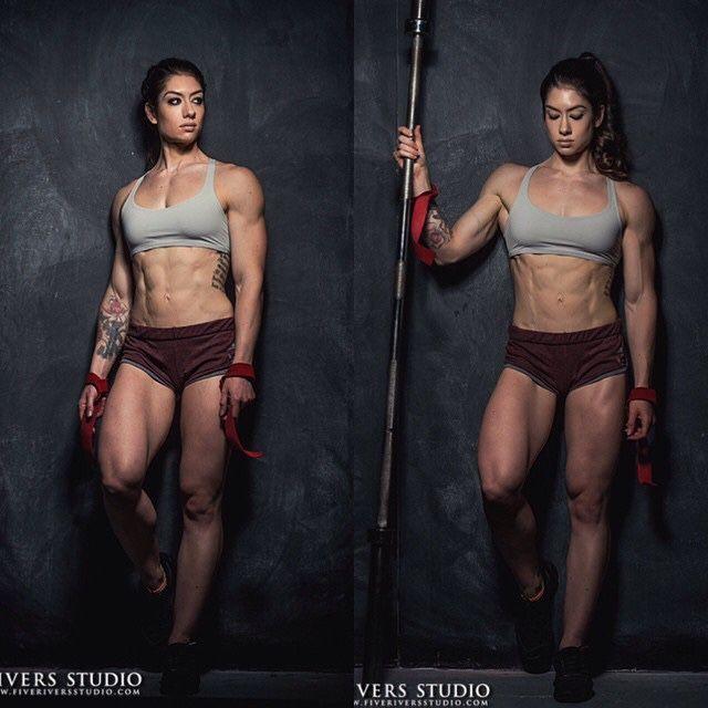 the image features a muscular woman in two different poses against a dark gray backdrop. she's wearing a gray sports bra and maroon athletic shorts, highlighting her physique. in both poses, she holds red wrist wraps, and on the right, she leans on a barbell with more red wraps. the image exudes strength and athleticism, typical of fitness photography.