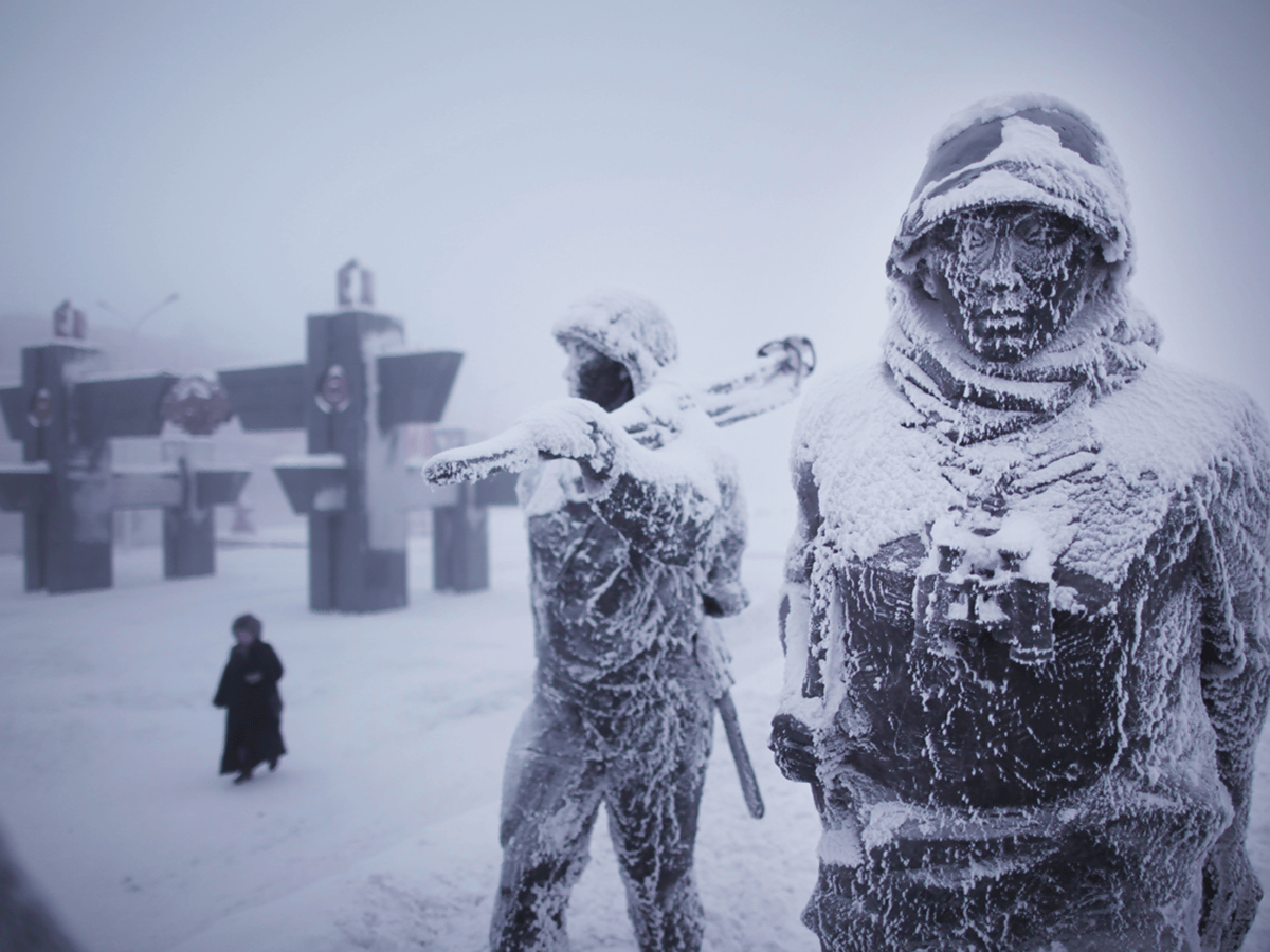 a closeup shot of two frozen statues of soldiers in the snow. the statues are covered in ice and frost, and the snow is piled high around them. the statues are in the background of a building. the snow is falling in the background.  the statues are a reminder of the harsh conditions that soldiers faced in the arctic during world war ii. the snow is a symbol of the cold and unforgiving environment that the soldiers had to endure.