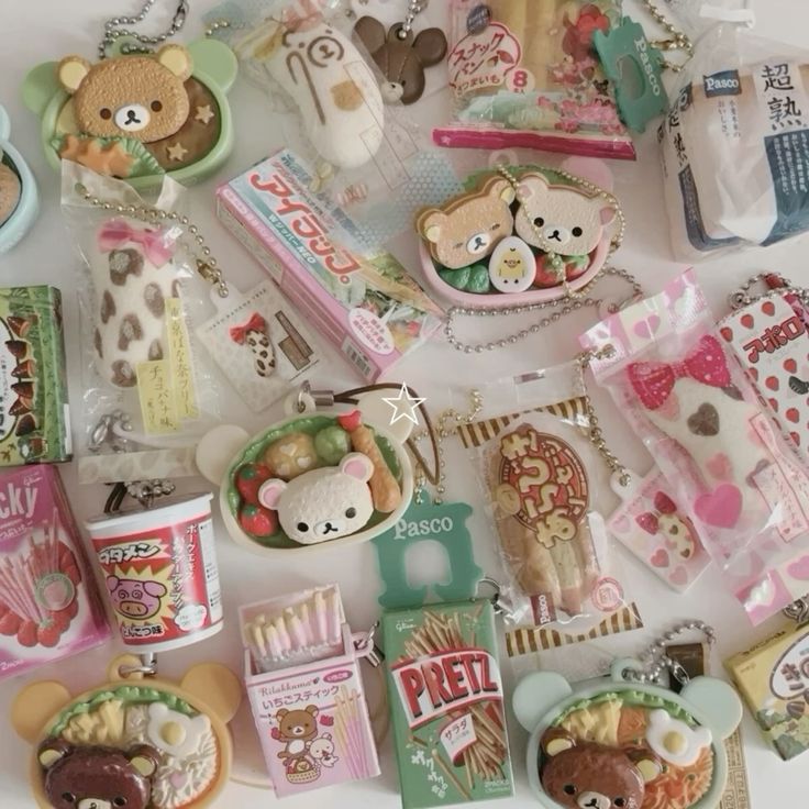 the image shows a collection of japanese snack keychains. there are several rilakkuma bento box keychains along with candy keychains like pocky, pretz, apollo, and pasco bread keychains.