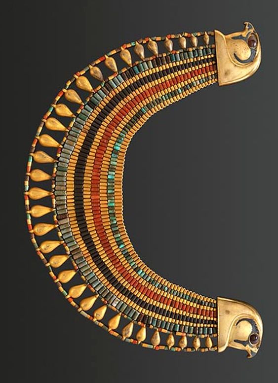 a wide, gold, ancient egyptian necklace with falcon head terminals. the necklace is made of gold, turquoise, carnelian, and lapis lazuli, with alternating bands of color and teardrop shapes. the falcon heads have inlaid red eyes.