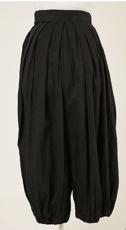a pair of black, baggy, highwaisted pants with pleats at the waist and gathered ankles. they appear to be a style similar to bloomers or harem pants.