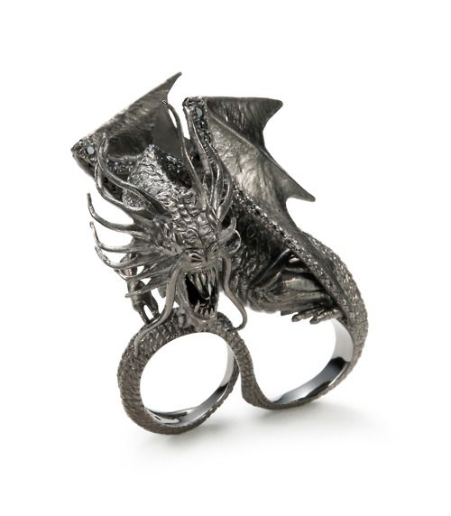 a silver dragon ring featuring a detailed dragon figure spanning across two rings designed to be worn on two fingers. the dragon has intricately designed wings, claws, and a menacing expression with visible teeth. the overall style of the ring is gothic and ornate, making it a statement piece.