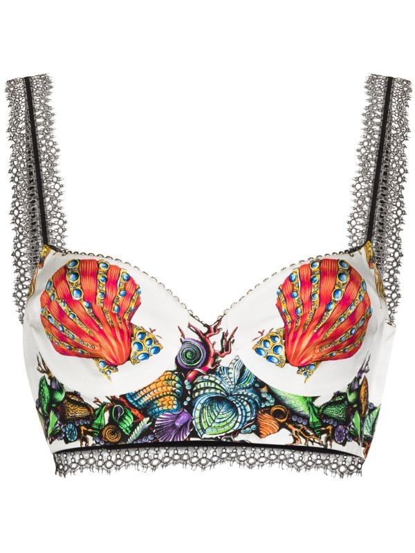 a white bra top with a seashell pattern and lace trim. the top has two red seashell patterns on the cups, adorned with blue jewels. the lower part of the top features various colorful seashell and coral illustrations in blue, green, orange, and purple hues. black lace trim adorns the bottom and upper edges of the top, while the straps are also black with a lace trim.