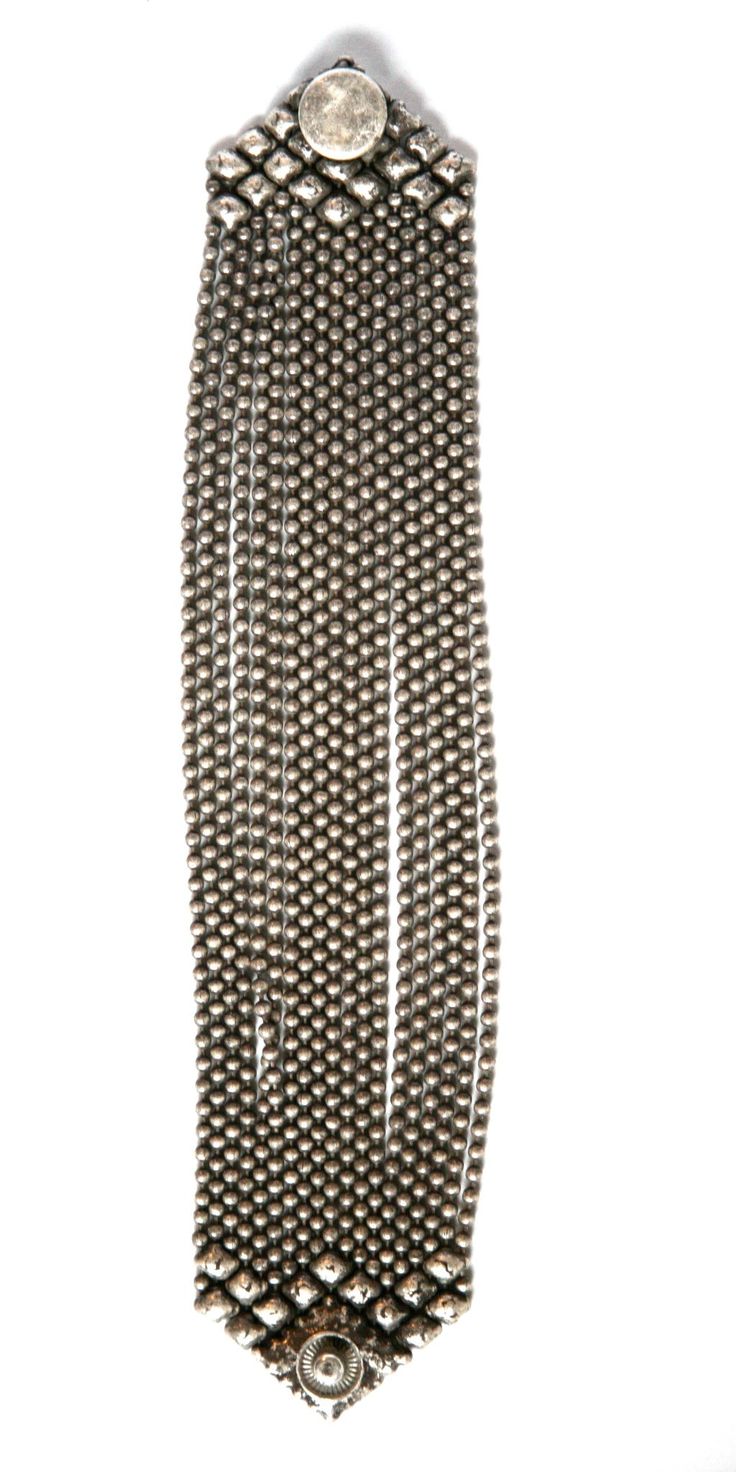 a silver beaded bracelet is shown in the image. the bracelet consists of multiple chains of tiny silver beads. the bracelet is a unique piece of jewelry that can be worn on any occasion. the design of the bracelet is simple but elegant, making it a perfect gift for a friend or loved one.