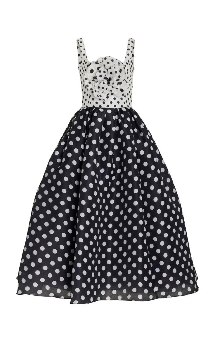 a black and white polka dot dress with a sleeveless bodice and a sweetheart neckline. the dress is made of a lightweight, flowy fabric. the dress is perfect for a formal occasion such as a wedding or prom. there is a large bow at the top of the dress. the dress is a vintage style and will make a statement.