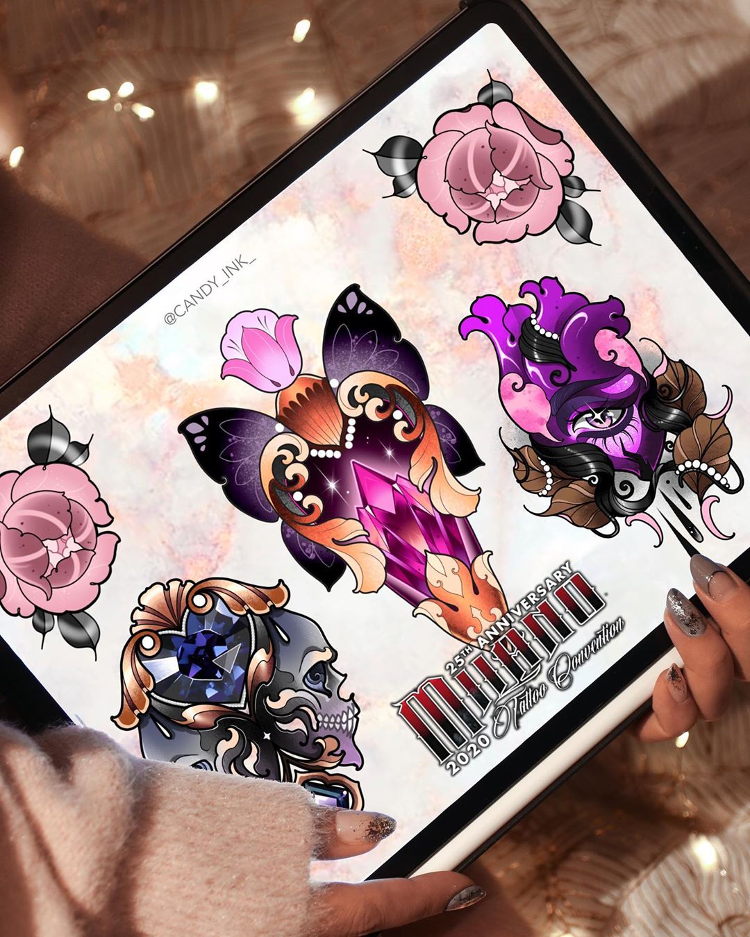 a hand holds up an ipad showcasing a digital illustration of tattoo designs in a neo traditional style. the designs are for a tattoo shop's 25th anniversary and feature a butterfly, rose, skull, heart, and crystal.