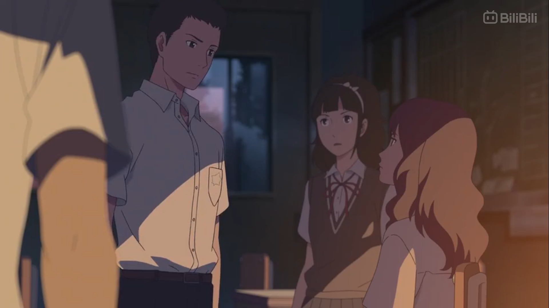 the image shows a scene from an anime, likely set in a school classroom. three teenagers, two girls and one boy, are engaged in a serious conversation. the lighting suggests it's late afternoon, with warm sunset hues bathing the room. the perspective is from a side view, partially obscured by another person's arm in the foreground, adding to the intimate and potentially tense atmosphere of the scene.