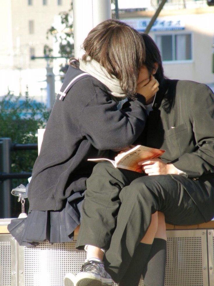 a couple is sitting on a bench,