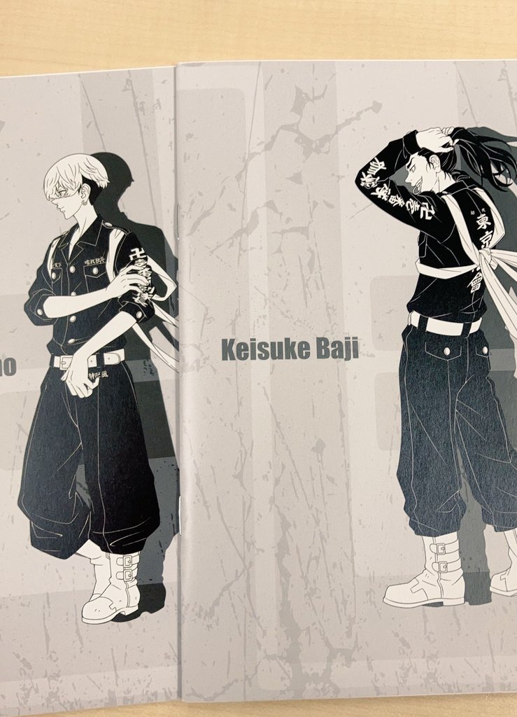 the image is a manga illustration of two characters. on the left side of the image, we see a young man with short hair. he is wearing a black jacket, pants, and boots. he has a dark expression on his face. on the right side of the image, there's another young man with his hair up. he is wearing a black jacket with a white shirt underneath. he is wearing black pants and boots. he has a white cloth wrapped around his waist. he looks more friendly than the other man.