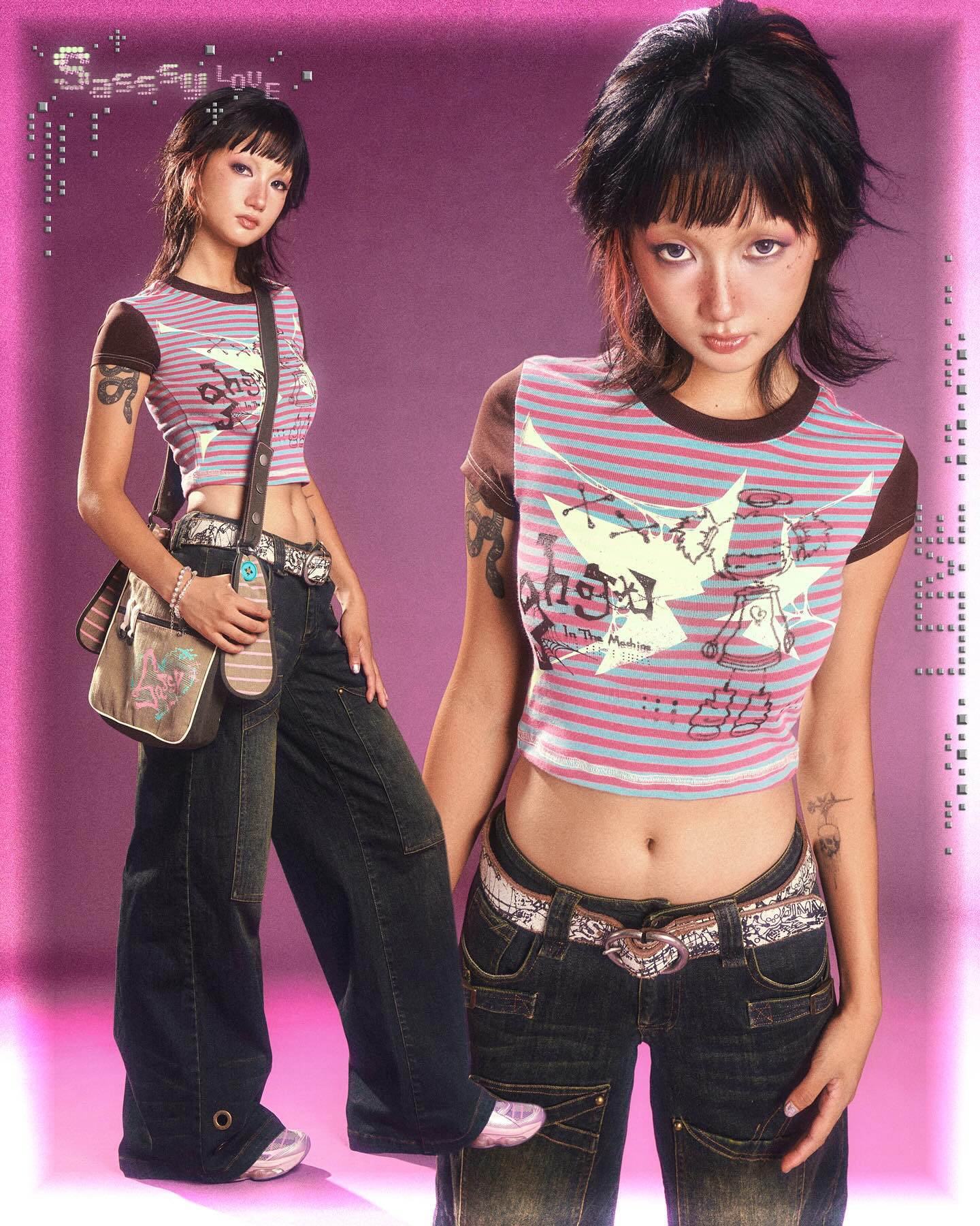 wo young women are posing in a studio setting against a bright pink backdrop.  they are wearing similar outfits, which are typical of y2k fashion: lowrise baggy jeans, striped crop tops with graphic designs, and belts. one woman is holding a handbag. their hair is styled in a similar short, choppy manner popular during that era. the overall aesthetic is distinctly reminiscent of the early 2000s fashion trends.  the image includes text overlay that says "sassy luv" suggesting a brand or theme.