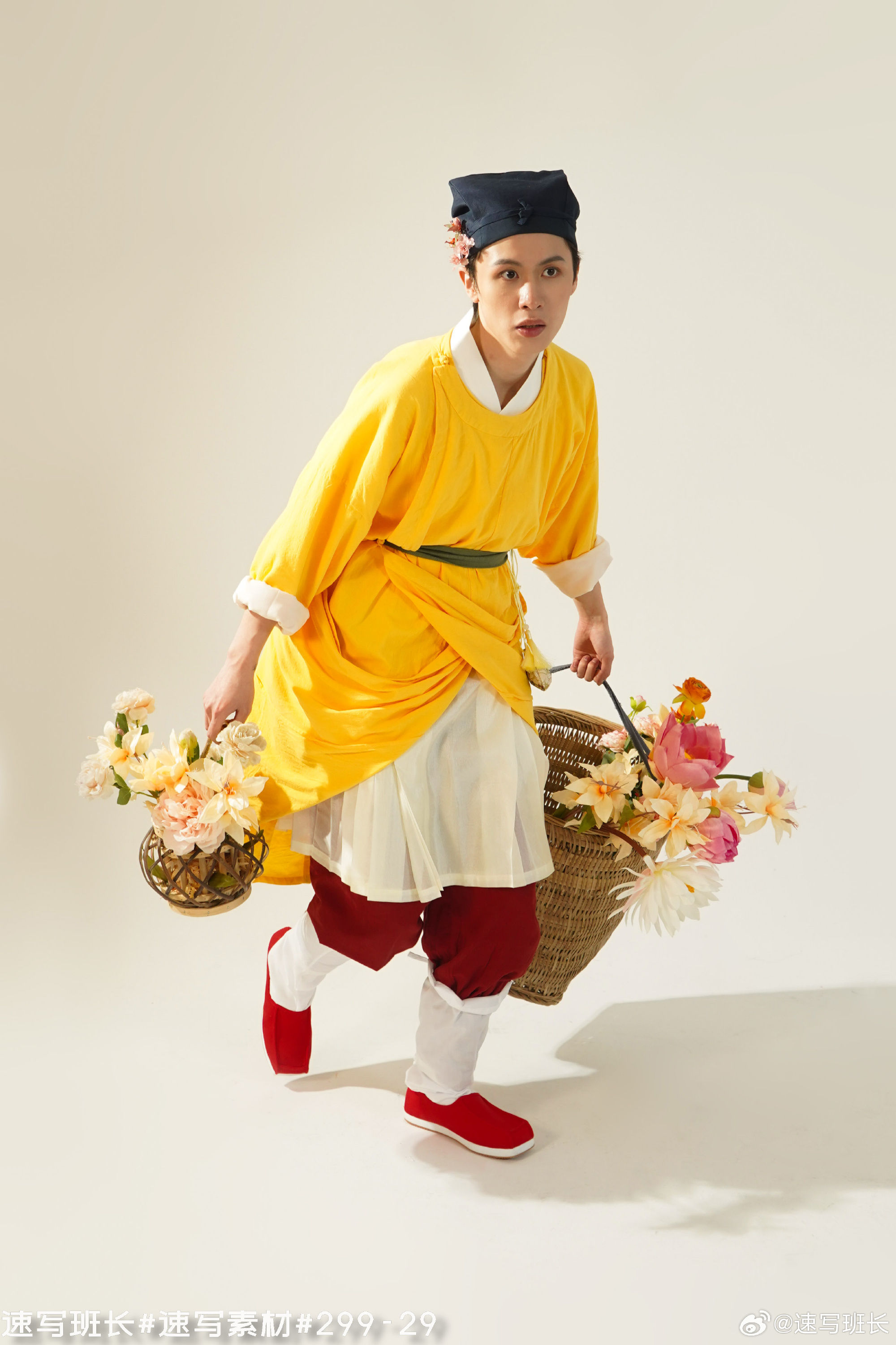 a person is wearing a vibrant yellow hanfu, a type of traditional chinese clothing, and red shoes. they are carrying two baskets filled with colorful flowers, one in each hand, and appear to be walking or lightly jogging forward. the background is plain white, suggesting a studio setting.