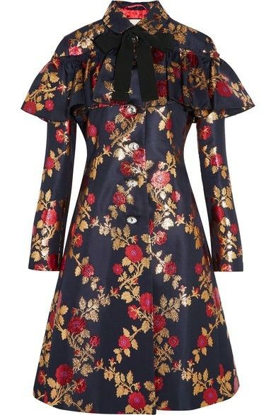 a navy coat dress with red floral and gold foliage print is displayed on a white background. the dress has a bow at the collar, ruffled accents, and long sleeves.