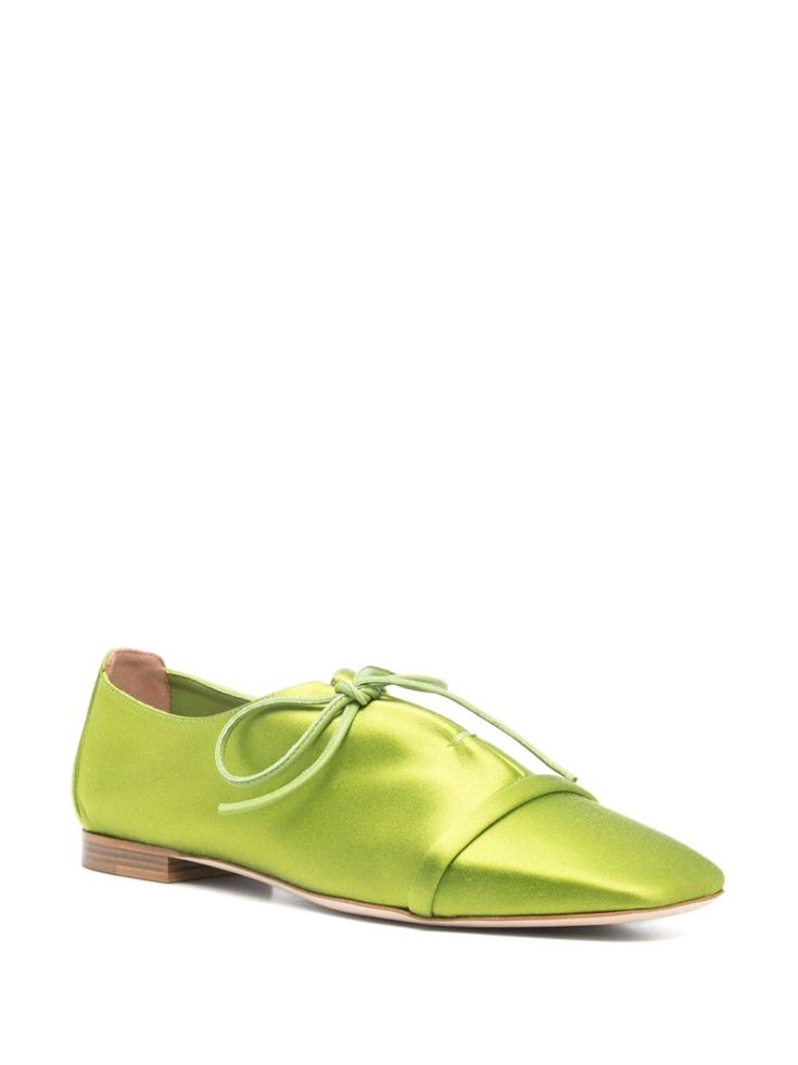 a pair of green satin laceup women's flats. the shoes have a rounded toe and a low heel.  the laces are tied in a bow at the front of the shoe.