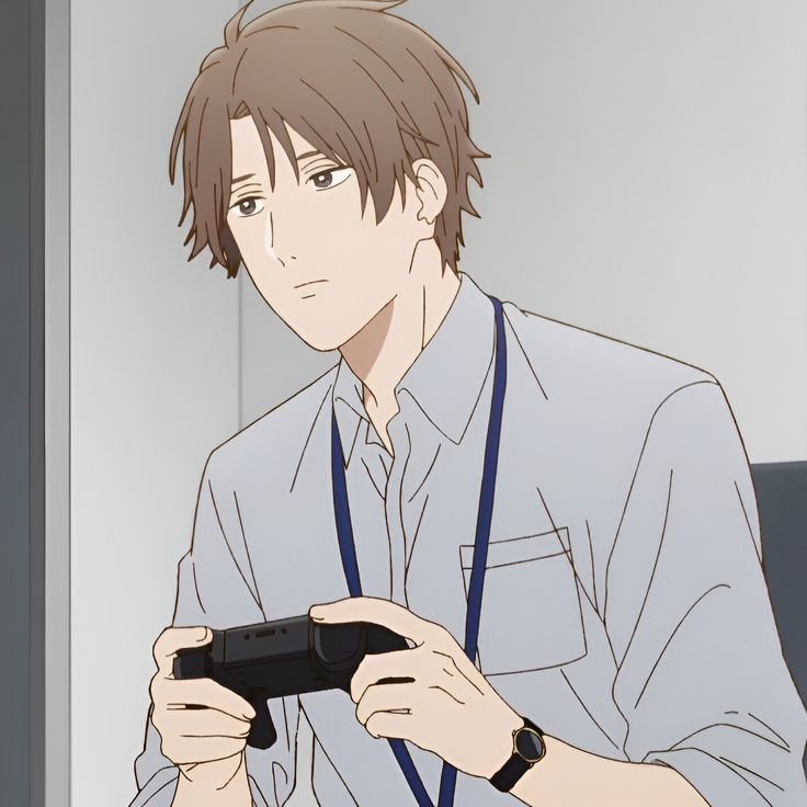 a lightskinned man with brown hair and brown eyes, potentially in an office setting, is looking down at a black video game controller he's holding in his hands. he's wearing a light gray, collared, buttondown shirt, a dark blue lanyard, and a brown wristwatch. he appears disinterested or bored. the image is a closeup of his upper body, taken from slightly below eye level. the lighting suggests a soft, natural light source.