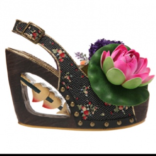 a single, highheeled shoe with a wedge heel. the shoe has a floral pattern and is decorated with a water lily. it has an open back and a buckle. the heel has cutouts with embellishments inside.