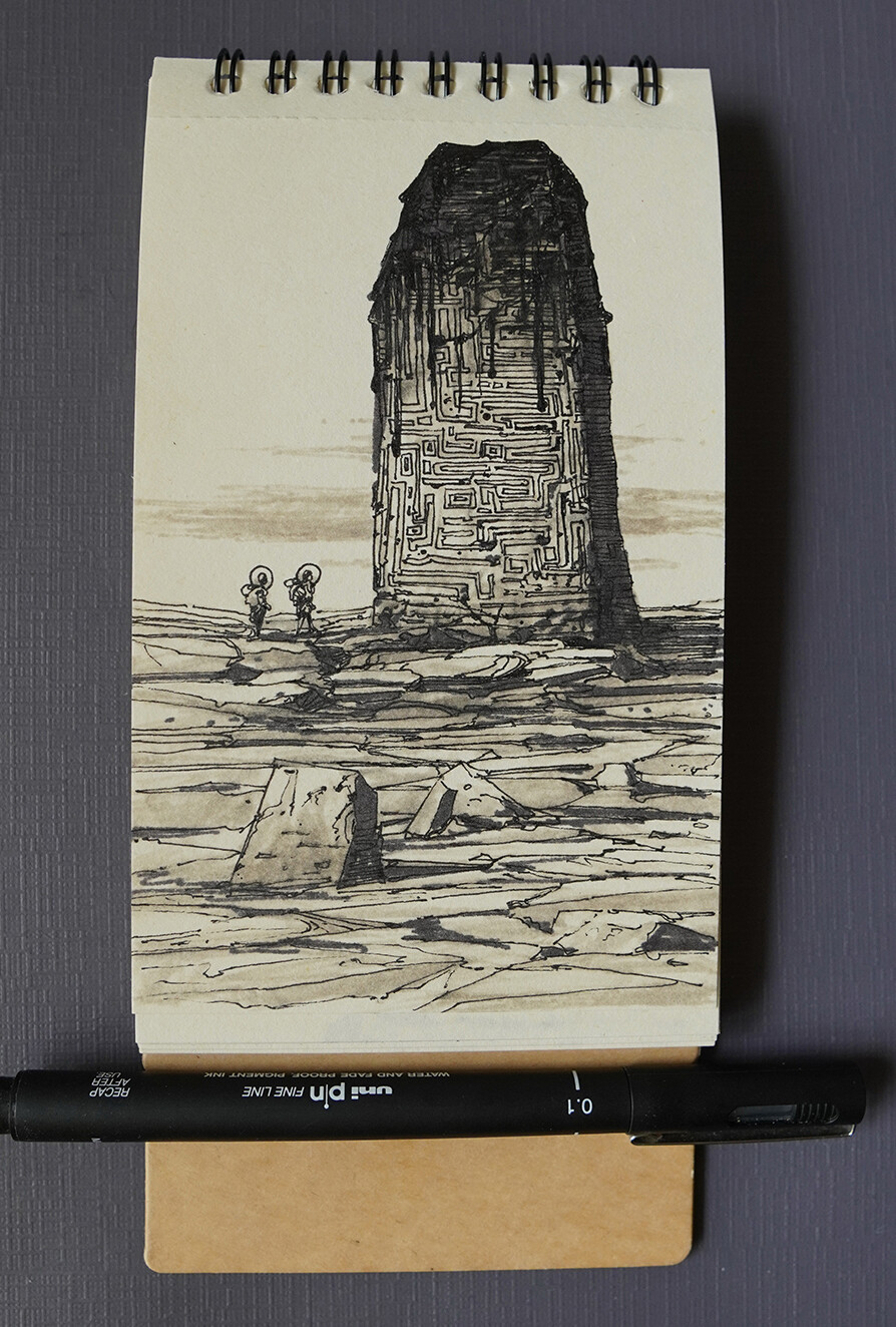 a black and white pen and ink drawing of a surreal landscape. the drawing depicts a towering, textured structure that resembles a maze. in the foreground, two figures are walking towards the structure on a cracked, desertlike landscape. the artwork is sketched in a notebook, with a black uni pin fine line pen lying on top of the notebook.