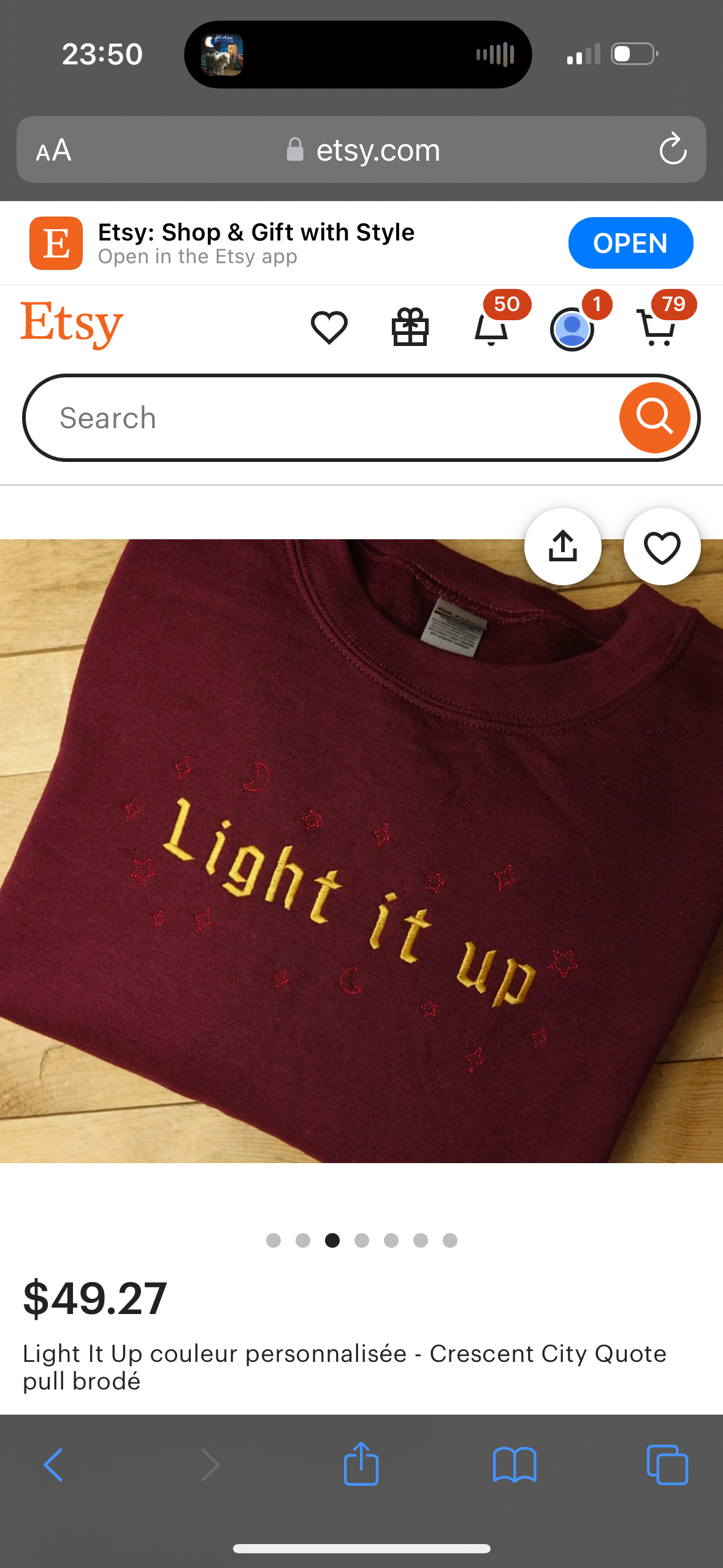 a maroon sweatshirt with the words "light it up" embroidered in gold on the front is pictured. the sweater is on a white background and there are multiple dots at the bottom of the picture. the text "light it up couleur personnalisée  crescent city quote pull brodé" is shown below the sweatshirt. the image is also labeled with "etsy" at the top and a price of $49.27. the etsy website is open in a browser, and the image shows a search bar, a shopping cart icon, and a heart icon.