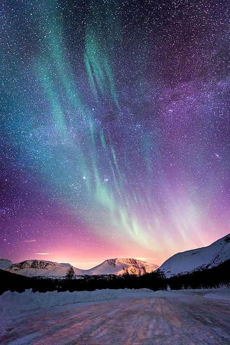 this is a breathtaking night scene of the aurora borealis, or northern lights, dancing over a snowcovered mountain range. the vibrant green, blue, and purple hues of the aurora fill the sky, creating a magical and ethereal display. the vast expanse of stars twinkling above adds to the wonder and beauty of the scene. the mountains in the foreground are shrouded in snow, creating a contrast between the vibrant colors of the sky and the stark white landscape. the scene is both peaceful and powerful, evoking a sense of awe and wonder. it's a reminder of the beauty and grandeur of the natural world.