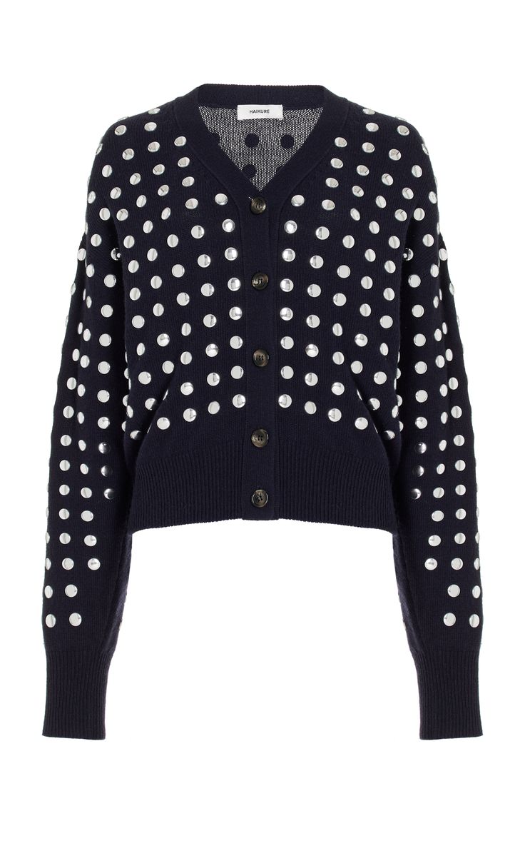 a women's navy blue cardigan with silver polka dots. the cardigan has long sleeves, a button closure, and a knitted fabric.