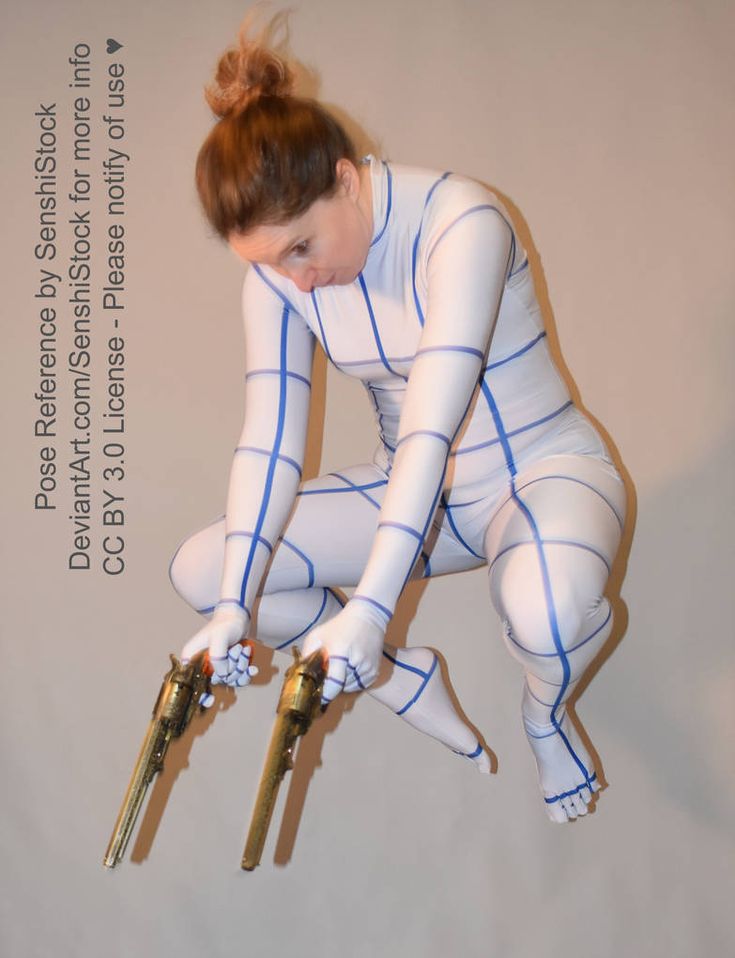 a woman dressed in a white bodysuit with a blue grid pattern jumps and points two guns, one in each hand. she's looking down at the gun. she has red hair and is wearing a bun. the background is light grey.