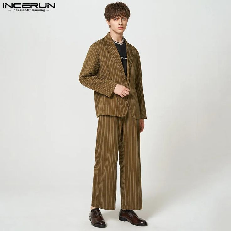 a man is wearing a brown striped suit with a blazer and pants. he is also wearing brown shoes. he is standing in a studio with a white background. he is posing for the camera.  the suit is formal wear, suitable for a business meeting or special occasion.