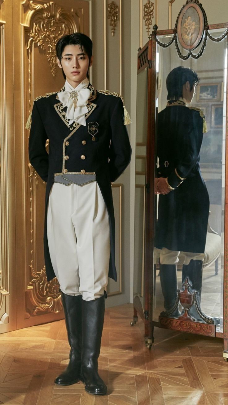a man stands indoors wearing a suit, reflected in a mirror. he is wearing a black jacket, white pants, and black boots. the background includes ornate gold decorations and a wooden floor.