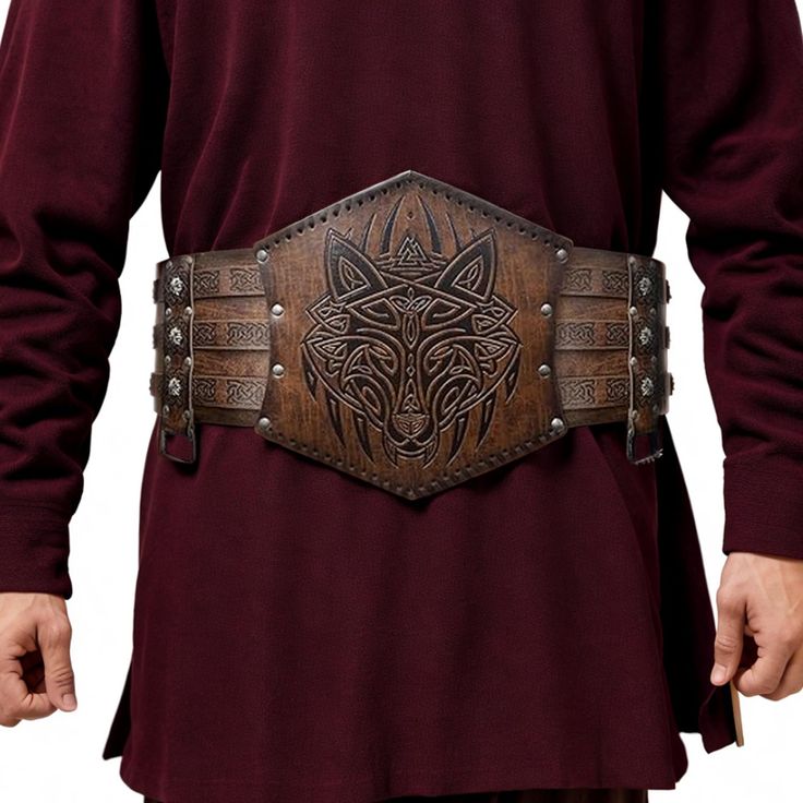 a person is wearing a wide, brown leather viking belt with a wolf design over a maroon tunic. the belt is decorated with celtic knots and secured with metal studs. the overall style suggests medieval or historical reenactment clothing.