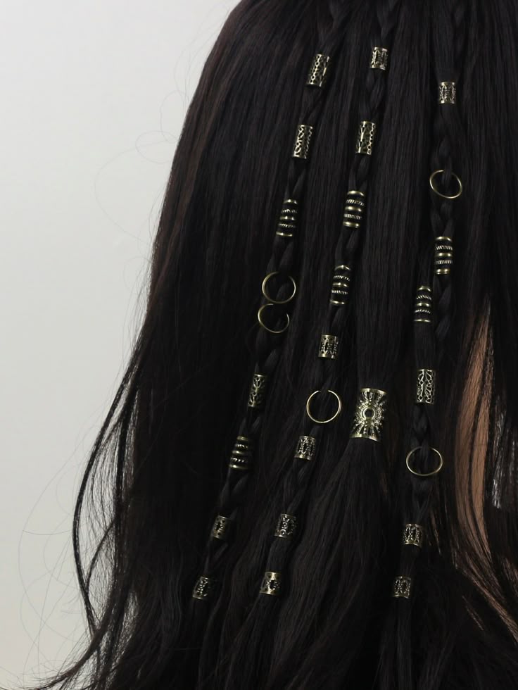 a closeup shows black hair with small braids decorated with goldtoned hair beads. the beads are cylindrical or ringshaped and adorn the braids at intervals.