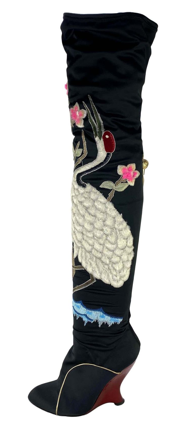 a pair of black satin high heel boots with embroidered crane and flower details. the boots are a wedge style with a slight curve to the heel. they are kneehigh and have a gathered top. the embroidery is done in various colors including pink, white, and blue. the overall style is elegant and sophisticated with an asianinspired design.