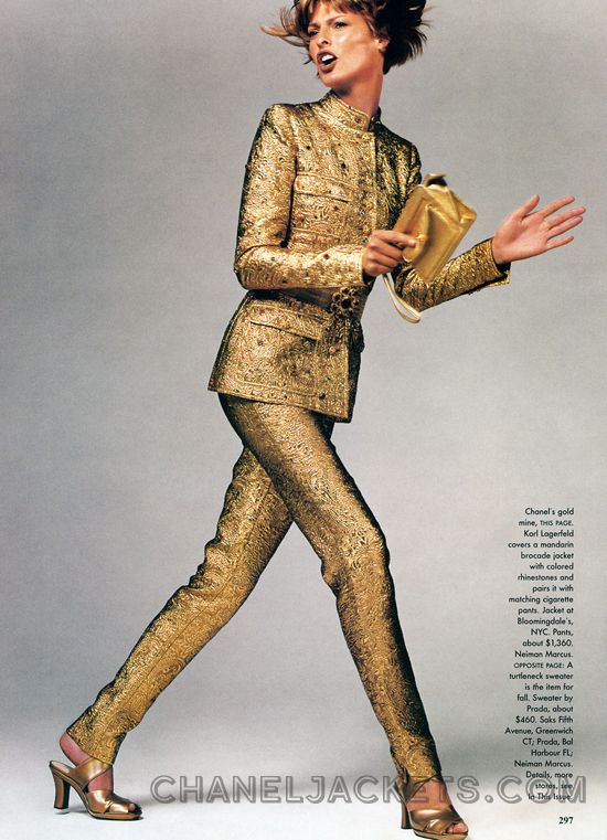 fulllength shot features a fashion model wearing a stunning gold brocade chanel pantsuit. the suit, designed by karl lagerfeld, is detailed with colored rhinestones and pairs perfectly with matching cigarettestyle pants. the model, with her hair slightly tousled, exudes confidence as she poses in a dynamic stride, showcasing the luxurious texture and impeccable tailoring of the ensemble.  she carries a gold clutch. the background is a simple, neutral gray, drawing complete focus to the outfit and model. the image is clearly from a highfashion magazine or editorial shoot of the 1990s.  the caption provides retail details regarding where the clothing items could be purchased.