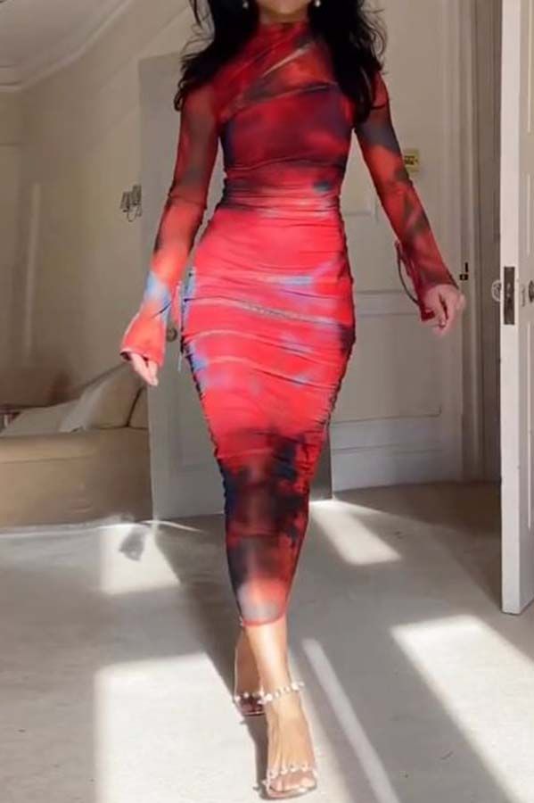 a woman in a red tiedye mesh longsleeve midi dress is walking down a hallway. she is wearing high heels and looks stylish and elegant. the dress is formfitting and shows off her figure.  the setting appears to be a welllit home or apartment.