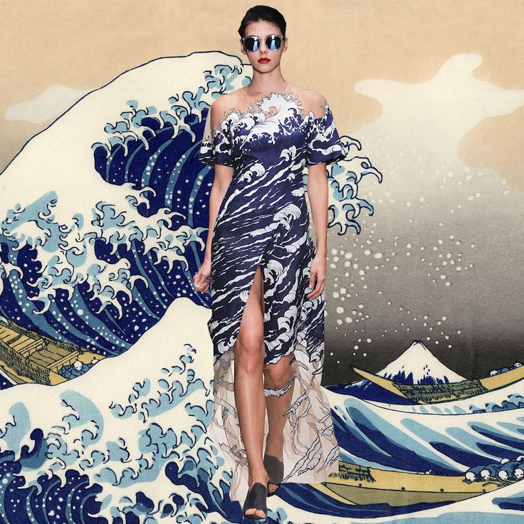 a fashion model walks the runway in a dress with a print of hokusai's the great wave off kanagawa. the dress is a deep blue and white pattern with a high slit up the front. the model is wearing sunglasses and walking with a confident stride. the background is a large image of the great wave off kanagawa.