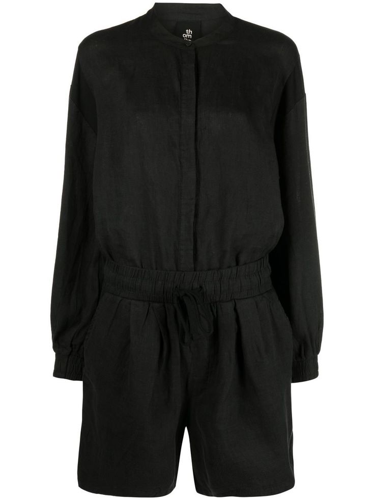 a black linen jumpsuit with long sleeves, a buttondown front, and a relaxed fit. it features a collared neckline and a drawstring waist. the jumpsuit is casual and comfortable, perfect for summer or spring. it is also a great option for fall or winter, layered with a sweater or jacket.