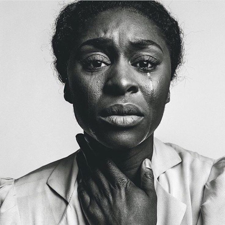 a black and white portrait of a woman with her hand up to her throat. tears are streaming down her cheeks and she has a sad look on her face. she is likely experiencing emotional pain.