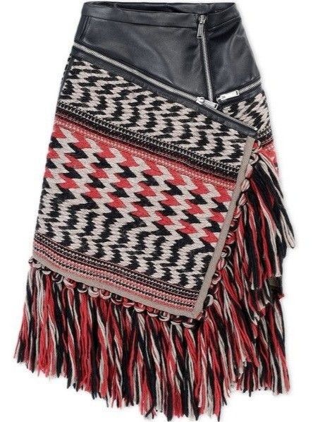 an asymmetrical skirt with a leather waistband, a chevron pattern in shades of white, black, and red, and a fringe trim in the same colors. the skirt has a zipper detail at the waist.