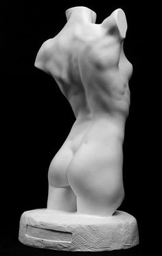 a white plaster sculpture of a female nude figure, the sculpture is positioned on a