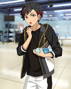 a young man with black and red hair is standing in a gym. he is wearing a black and white jacket and is holding a water bottle. he is looking to the left and is talking.