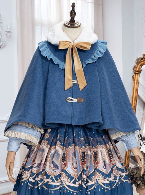 a blue winter cape with a faux fur collar is displayed on a mannequin. the cape is paired with a lolita style dress and a gold bow.