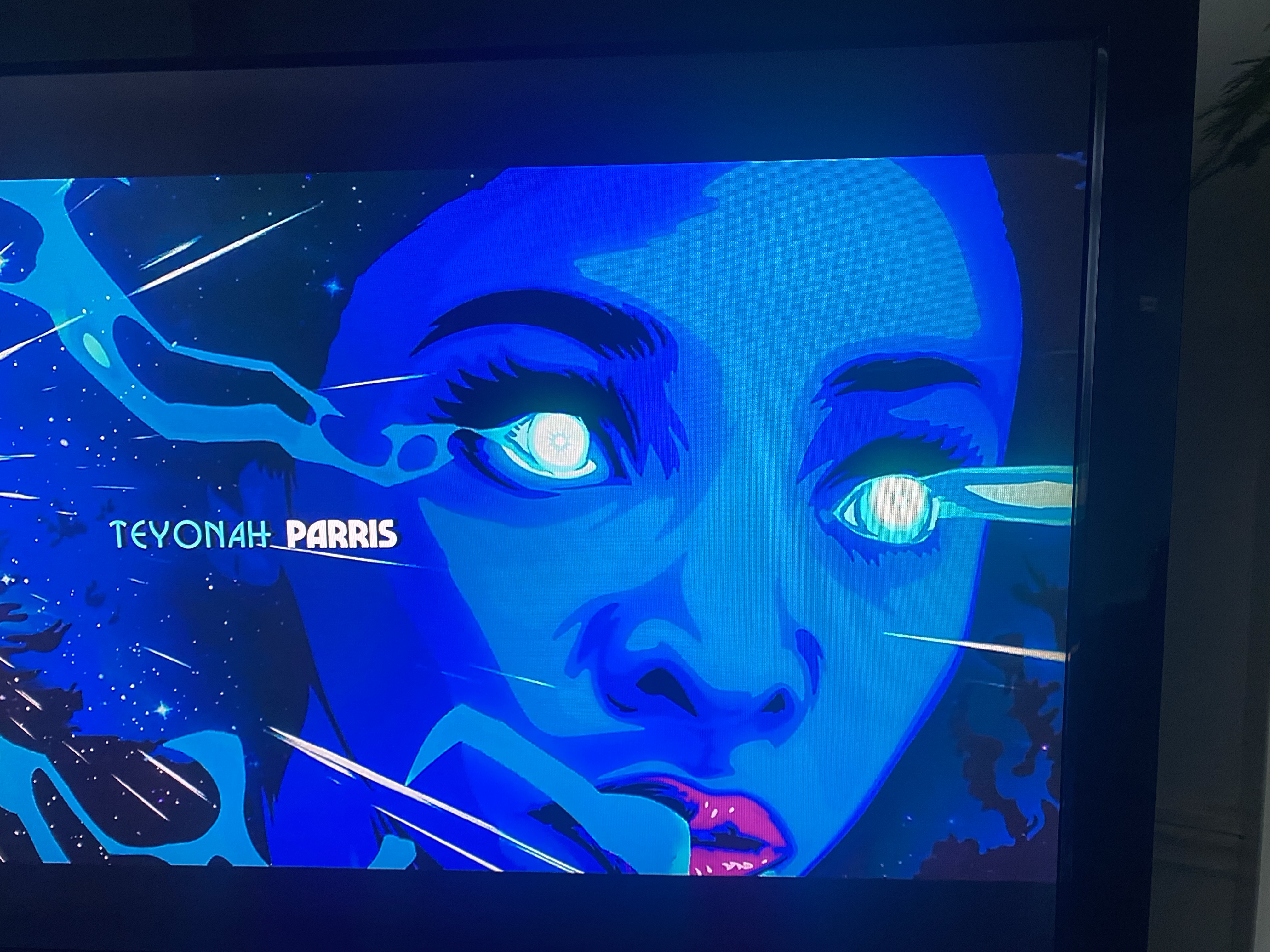 a closeup portrait of teyonah parris, the actress who plays monica rambeau in the tv series wandavision.  her image is displayed on a screen with a blue neon effect.