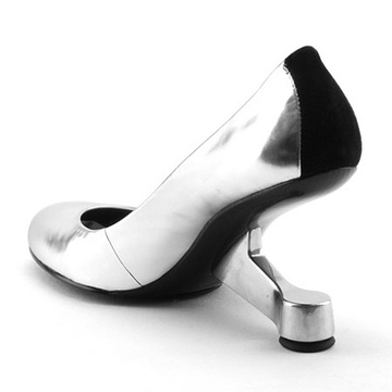 a silver and black pump shoe is displayed on a white background. the shoe has a unique heel design.