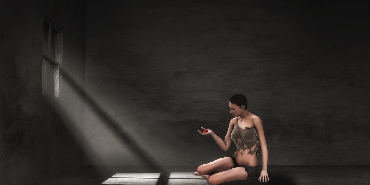 a woman in rags sits on the floor of a dark prison cell, illuminated by a beam of light from a window. she holds a small red object in her hand. the overall mood is one of despair and confinement.