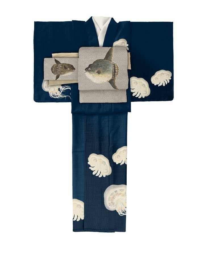 a navy blue kimono with images of ocean sunfish and jellyfish. the kimono has a white collar and is neatly folded. the obi (sash) features a large ocean sunfish, while smaller jellyfish patterns are scattered on the sleeves and lower part of the garment.