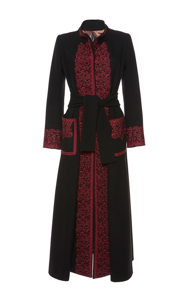 a longsleeved black abaya dress with red embroidery on the front, along the edges, and on the pockets. the dress has a belt.