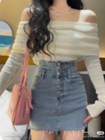 the image shows a woman wearing a white offtheshoulder sweater, a blue denim skirt with buttons down the front, and a pink purse. the image is taken indoors and features artificial lighting. the perspective is at eye level.