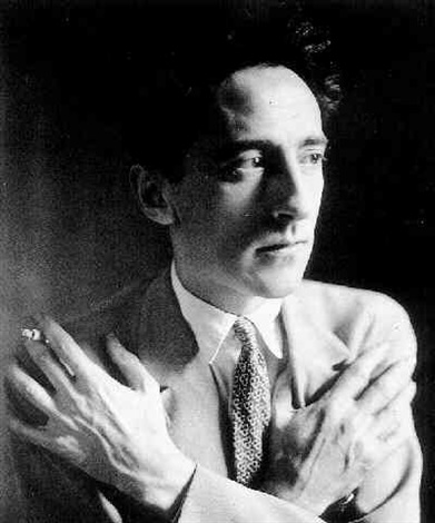 a black and white, closeup portrait photograph of a man, possibly from the 1930s or 1940s. he is dressed in a lightcolored suit and tie, his hands are clasped in front of his chest.  his expression is serious and contemplative, suggesting a thoughtful or pensive mood. the background is dark, creating a highcontrast image that emphasizes the subject. the photograph has a vintage quality, consistent with the style of portrait photography of the era.  the man’s attire and demeanor suggest he might be a writer, artist, or other intellectual figure.