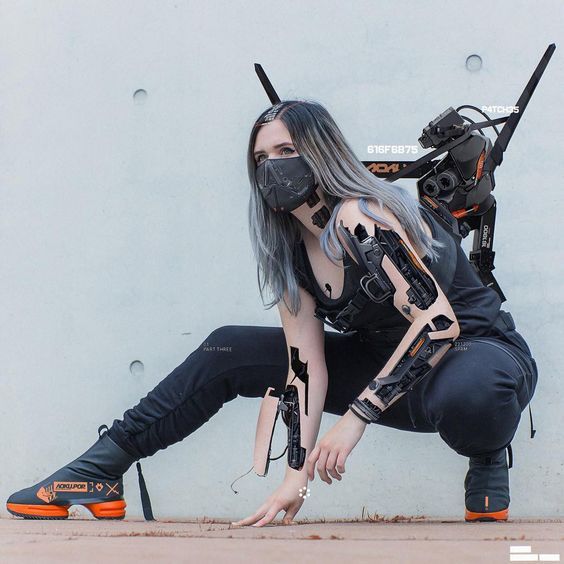 a woman dressed in cyberpunk attire, with robotic attachments,  a black mask, and a gray wig, crouches down in a fighting stance with one hand on the ground,  a gray wall behind her. she is wearing black boots with a visible, orange, futuristic design.  she is holding a black and orange weapon, and appears to be ready for a fight.  her hair is pulled back,  her eyes are shadowed.