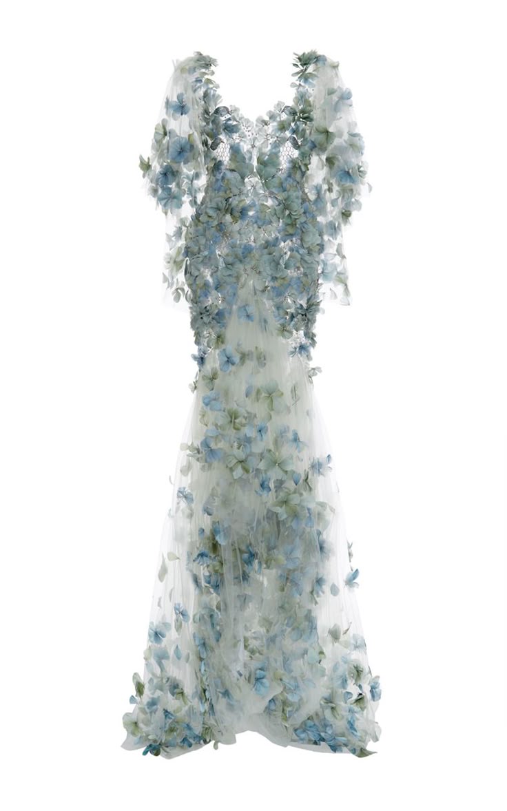 a long, ethereal gown adorned with blue and green flowers, creating a whimsical and romantic look. the dress appears to be made of tulle or a similar sheer fabric, and is likely a wedding dress or formal evening gown.
