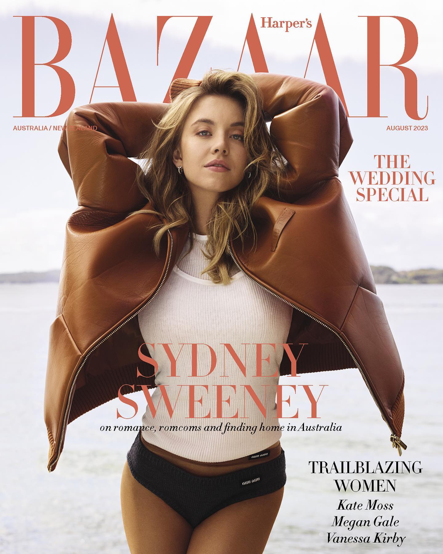 he image is a magazine cover featuring sydney sweeney for harper's bazaar australia/new zealand's august 2023 issue.  sweeney is prominently displayed, wearing a brown leather jacket and dark underwear, posed against a blurred beach background. the cover title emphasizes "the wedding special" and highlights other "trailblazing women" including kate moss, megan gale, and vanessa kirby.  the overall style is glamorous and sophisticated, typical of highfashion magazine covers.