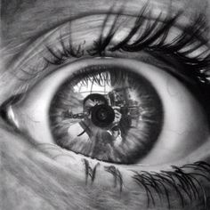 a close up, black and white photograph of a realistic drawing of an eye. the eye is looking directly at the camera and the iris is filled with a reflection of a photographer with a camera. the eyelashes are long and thick and the eyebrow is drawn with detail. the entire image is very realistic.