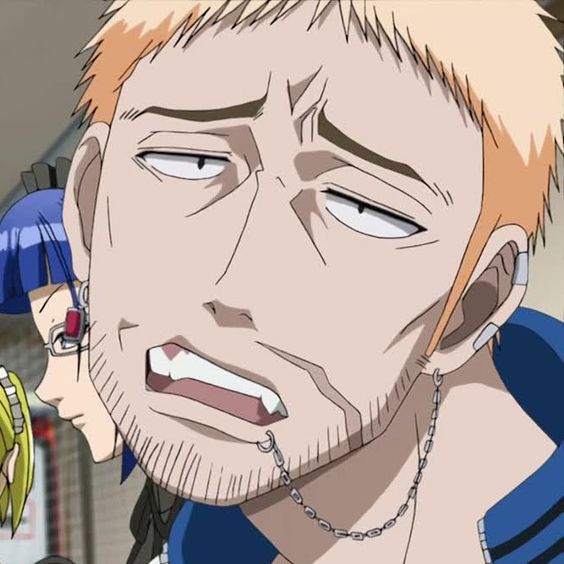 the image shows a boredlooking anime man with spiky blonde hair and sideburns. he has a lip ring connected to a chain around his neck and appears to be unshaven. he is inside, likely in a school or office setting, based on what can be seen of the people behind him.